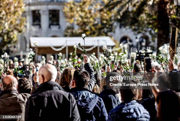 Crowd holds white flowers at a rally and minute of silence in memory of Cristina, a woman victim of gender violence, in the Plaza del Ayuntamiento,...