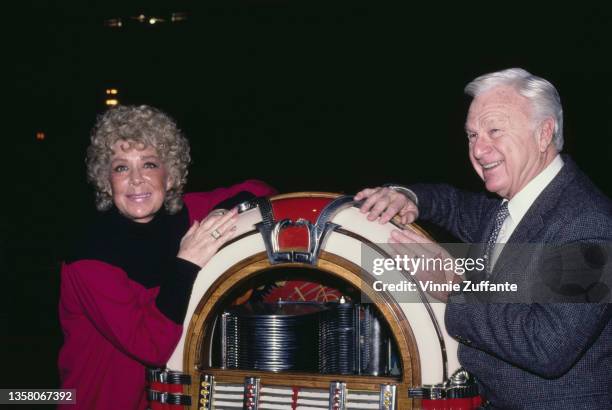 American actress, comedian and singer Betty Hutton and American actor Eddie Albert pose beside a jukebox as they attend a rehearsal for 'Jukebox...