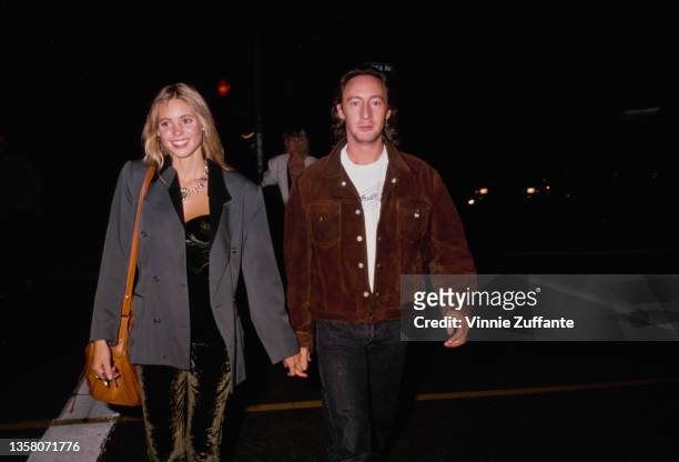 British actress Olivia d'Abo, wearing a grey jacket, and British singer, songwriter and photographer Julian Lennon, wearing a brown jacket, holding...