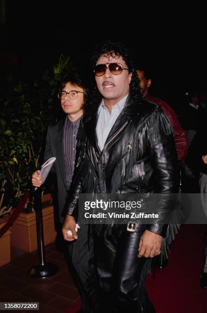 American singer, pianist and songwriter Little Richards, wearing a black leather jacket, leather trousers and sunglasses, attends the Century City...