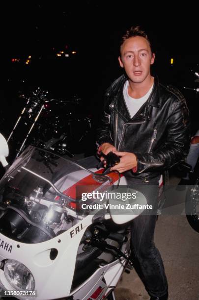 British singer, songwriter and photographer Julian Lennon, wearing a black leather jacket with a Yamaha motorcycle, attends the El Rescate Benefit...