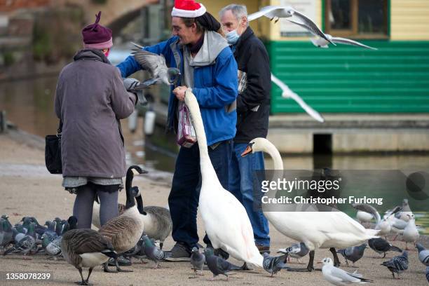 People feed swans, pigeons, gulls and geese next to the River Avon on December 09, 2021 in Stratford Upon Avon, United Kingdom. Stratford normally...