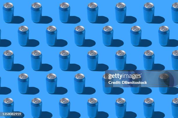 blue soda cans pattern with hard shadow on red background. - cannette photos et images de collection