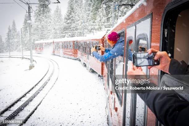 people photographing the snow from gornergrat bahn train - zermatt stock-fotos und bilder