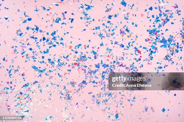 many blue and purple foil confetti on pink background. holiday backdrop. concept of new year coming party. flat lay style - confetti explosion stock-fotos und bilder