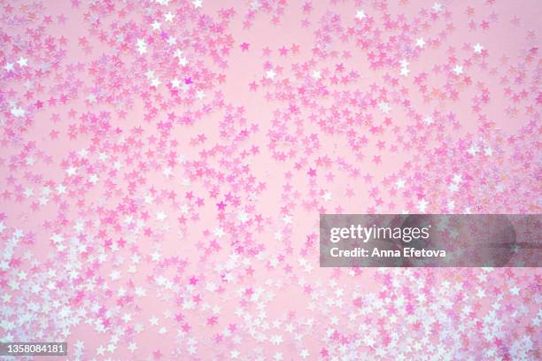 many small pink stars on pink background. holiday concept. flat lay style - pink background fotografías e imágenes de stock