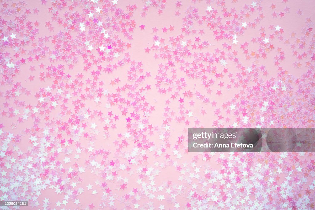 Many small pink stars on pink background. Holiday concept. Flat lay style