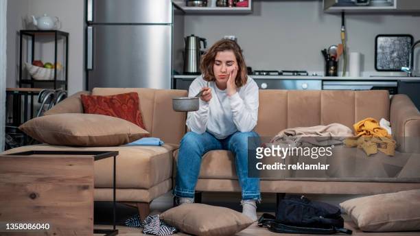 view of a female who is holding a pan because of water leak. 
view of an adult female who is holding a pan. because the ceiling is leaking water. everything’s messed up. insurance concept. - leaky roof stock pictures, royalty-free photos & images
