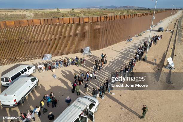 In an aerial view immigrant families are taken into custody by U.S. Border Patrol agents at the U.S.-Mexico border on December 07, 2021 in Yuma,...