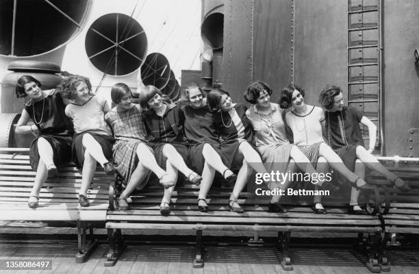 Dance troupe The Tiller Girls, all under 16, limber up on the deck of the SS Lacona, New York, 10th August 1925.