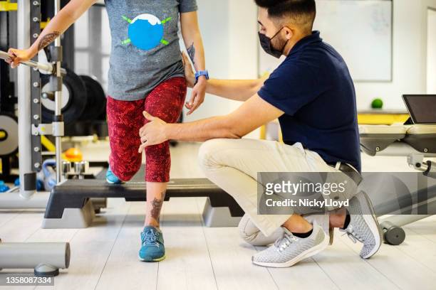 physiotherapist with face mask helping woman with cerebral palsy do lunges at rehab - checking sports stock pictures, royalty-free photos & images