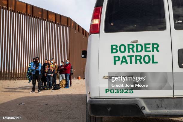 Immigrant men are taken into custody by U.S. Border Patrol agents at the U.S.-Mexico border on December 07, 2021 in Yuma, Arizona. Most had come with...