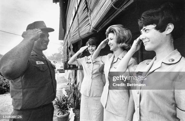 Private First Class Tom Fogg, of Stoughton MA, gets a bright greeting from the new arrivals of "Women Army Corps" members; the new arrivals, from...