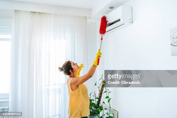 woman cleaning air conditioning system stock photo - broken air conditioner stock pictures, royalty-free photos & images