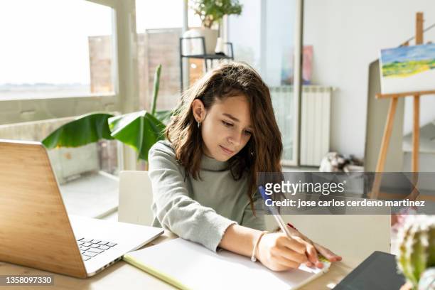 pretty teenage girl does homework at home desk - spanish literature stock pictures, royalty-free photos & images