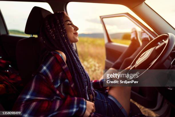 ruhige und unbeschwerte kaukasische junge frau, die eine pause von der autofahrt macht - voyage zen stock-fotos und bilder