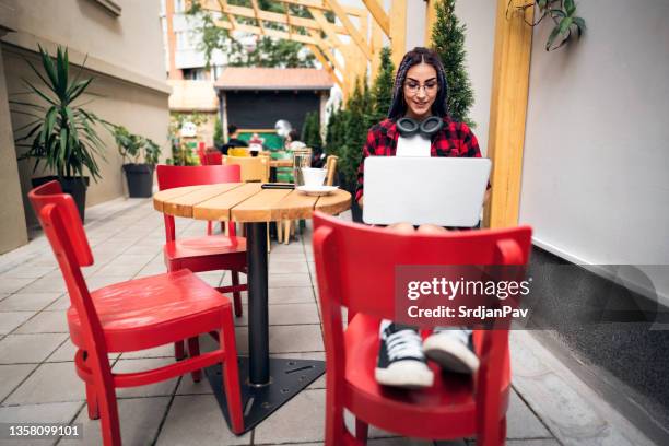 ruhige und sorglose bloggerin, die am laptop aus einem modernen café arbeitet - hipster coffee shop candid stock-fotos und bilder