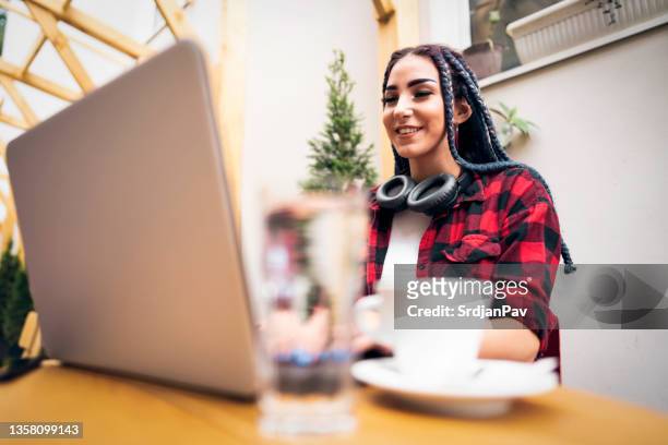 urban and cool young woman, working on a laptop from modern coffee shop - content stock pictures, royalty-free photos & images