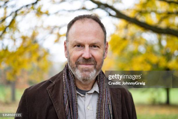 photo de tête d’un homme caucasien de 55 ans au milieu du feuillage d’automne - 50 year old photos et images de collection