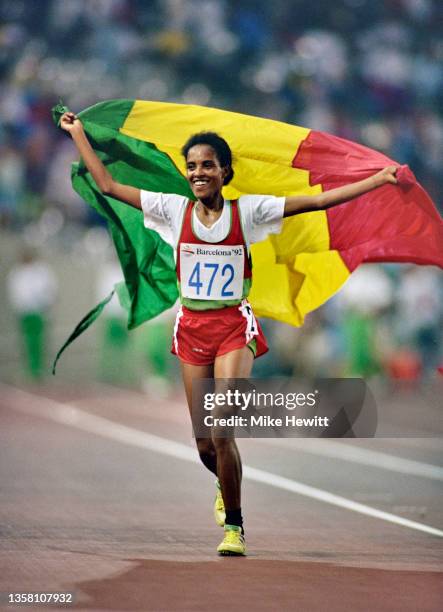 Derartu Tulu of Ethiopia raises her arms holding the national flag of Ethiopia in celebration after winning the Women's 10,000 metres on 7th August...