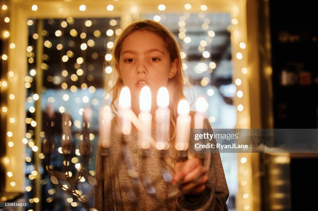 Girl Lighting Menorah For Hanukkah