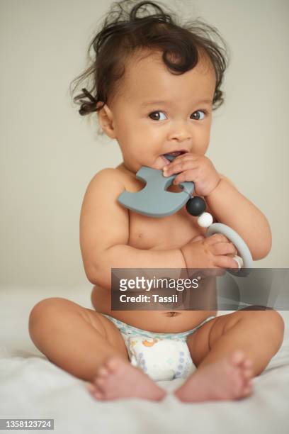 shot of an adorable baby girl playing with a teething rattle at home - baby rattle stock pictures, royalty-free photos & images