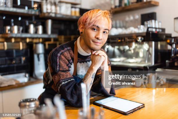 portrait of a barista standing behind cafe counter - hipster in a kitchen stockfoto's en -beelden