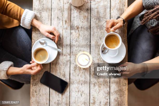 zwei freundinnen treffen sich in einem café - sitting drinking coffee man stock-fotos und bilder