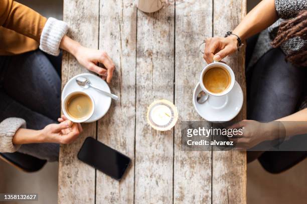 two woman friends meeting at a coffee shop - table discussion stock pictures, royalty-free photos & images