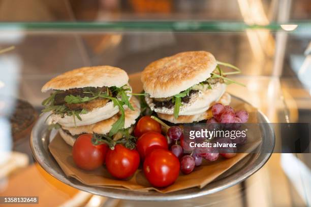 freshness delicious burgers on a plate with tomatoes and grapes on cafe food display - roast beef sandwich stock pictures, royalty-free photos & images