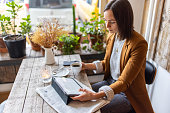 Businesswoman sitting at a coffee shop using digital tablet