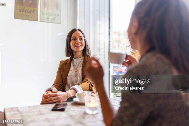geschäftsfrau trifft sich mit einer kollegin im café - 2 frauen gespräch ohne männer cafe stock-fotos und bilder