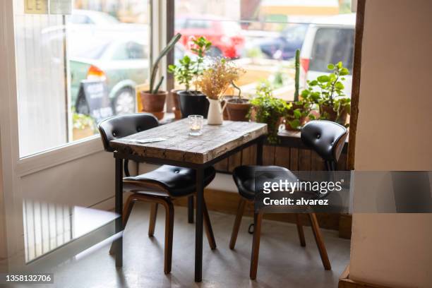 empty modern cafe table by the window - table brick wall wood stockfoto's en -beelden