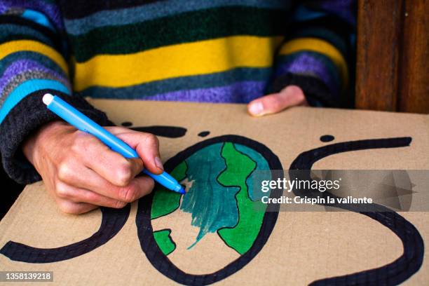 close up of a woman painting a cardboard banner about climate change - art for social justice stock pictures, royalty-free photos & images