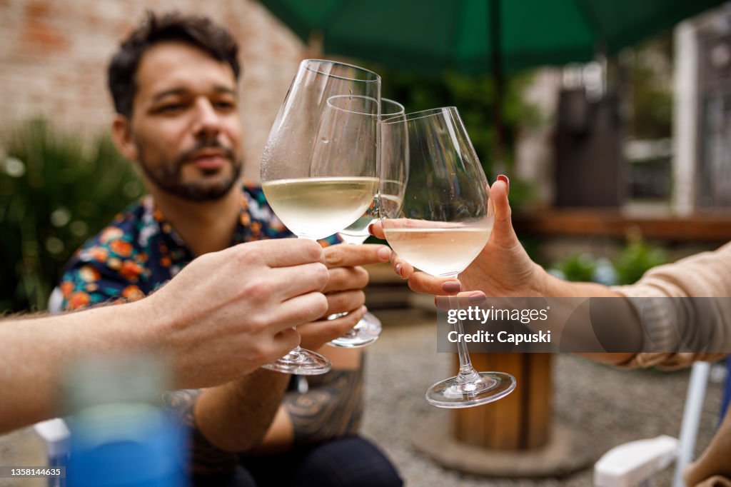 Gente brindando con vino blanco