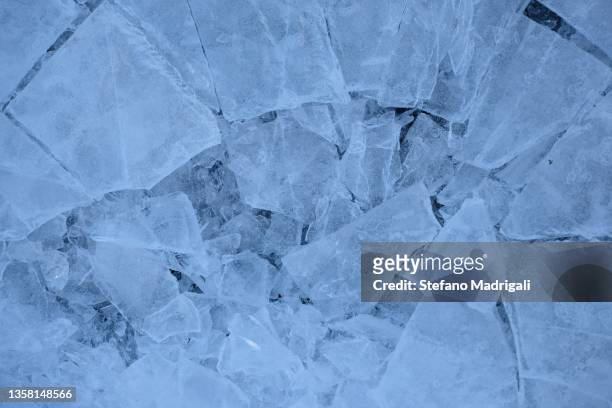 frozen water in the morning, crack in the center, broken - ice crack stock-fotos und bilder