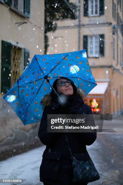 young girl shelters from the snow with an umbrella and observes the christmas lights - sleet bildbanksfoton och bilder