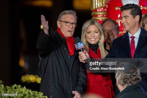 Steve Doocy standing next to Ainsley Earhardt is asked a question by Jesse Watters at the new All-American Christmas Tree lighting outside News...
