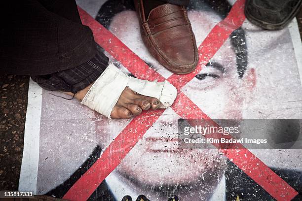 Anti-Mubarak protestor step on a Mubarak poster in Tahrir Square on February 6, 2011 in downtown Cairo, Egypt.