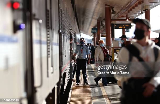 An Amtrak worker keeps watch as passengers depart at Union Station on December 9, 2021 in Los Angeles, California. Amtrak is having difficulty hiring...