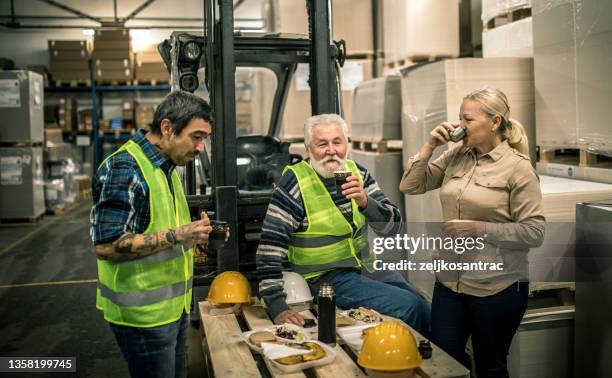 warehouse worker relaxing and eating lunch - senior lunch stock pictures, royalty-free photos & images