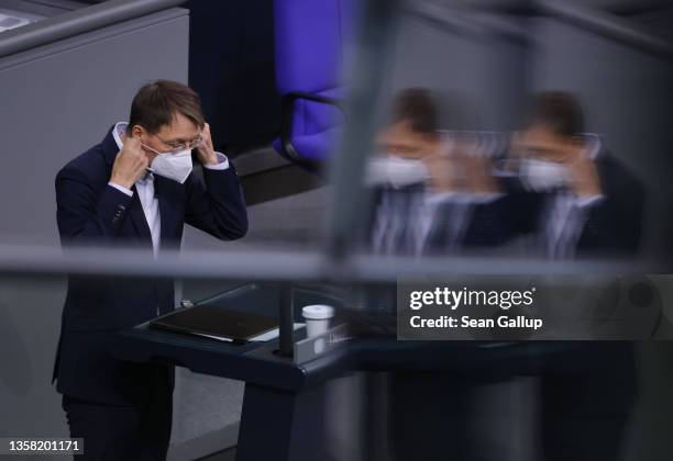 German Health Minister Karl Lauterbach dons a face mask after speaking at the Bundestag during debates prior to a vote on a new legislation that...