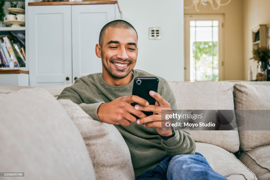 Foto de un joven usando su teléfono inteligente para enviar mensajes de texto