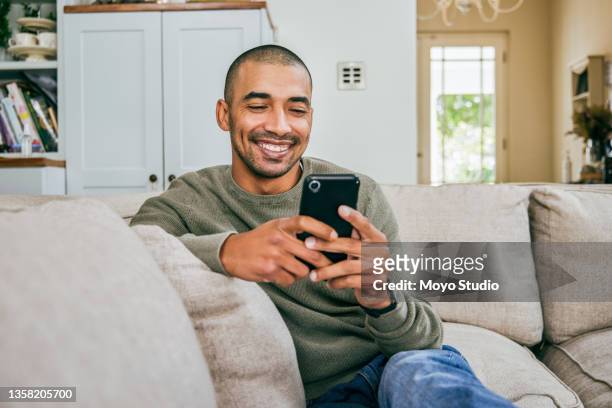 shot of a young man using his smartphone to send text messages - one person stock pictures, royalty-free photos & images