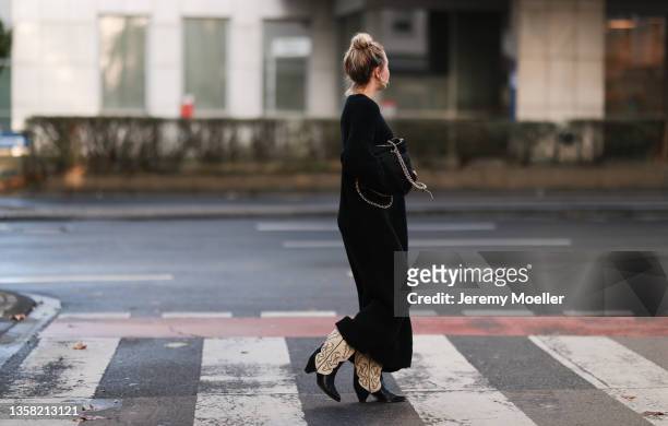 Henni wearing Isabel Marant Cowboy boots, Vival black knit dress and black Prada Nylon bag on December 07, 2021 in Cologne, Germany.