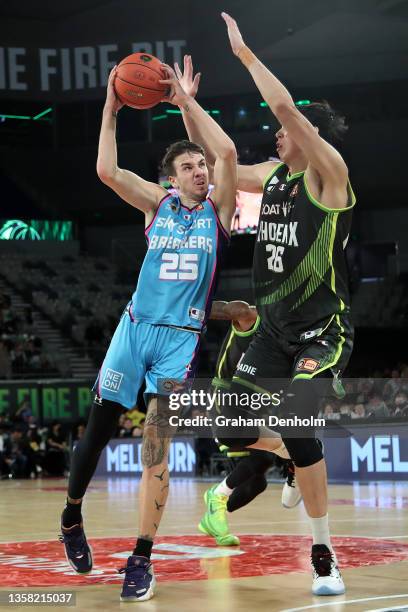 Hugo Besson of the Breakers (L drives at the basket under pressure from Zhou Qi of the Phoenix during the round two NBL match between South East...