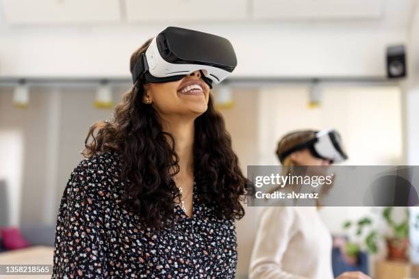 zwei geschäftsfrauen testen das metaversum mit neuer virtual-reality-brille im büro - virtual reality glasses stock-fotos und bilder