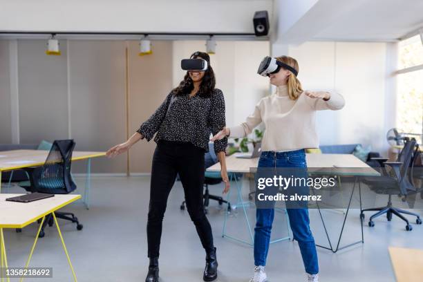 two businesswoman using virtual reality glasses at new office to enter the metaverse - vr glasses bildbanksfoton och bilder