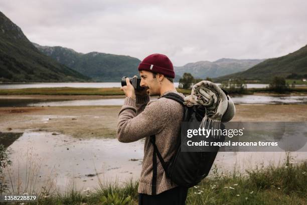 adult man with backpack taking a picture with his camera - photographer seascape stock pictures, royalty-free photos & images