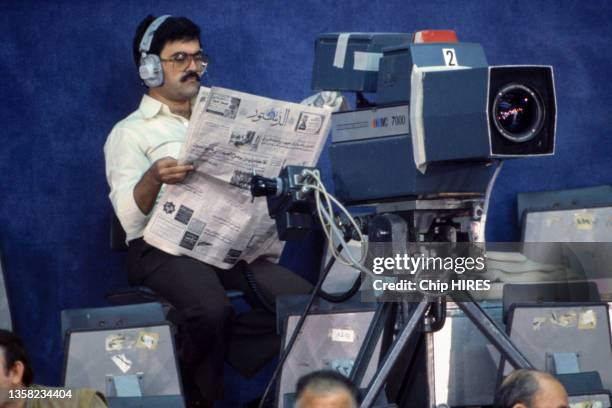Un caméraman lit le journal lors du Congrès National Palestinien, le 27 novembre 1984.